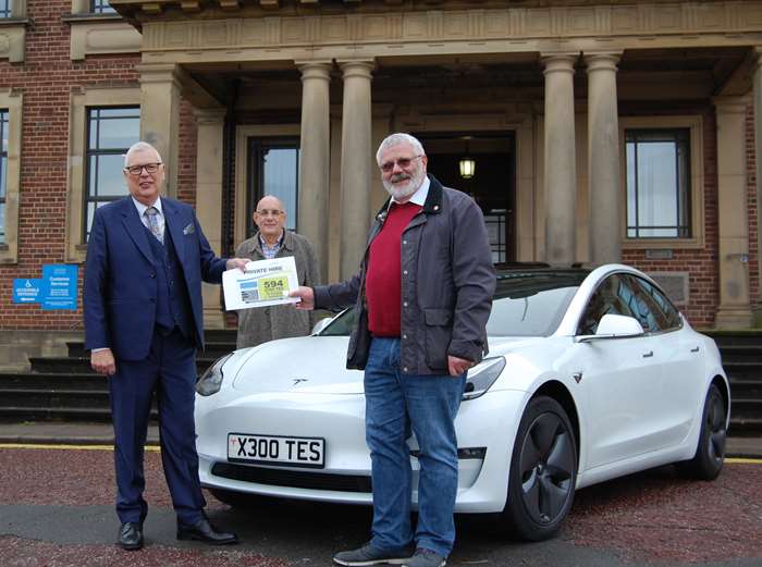 Stephen Brown (left) receiving his private hire plates from Coun Colin Hartley, chair of the council's licensing committee, watched on by Coun Kevin Frea, deputy leader.