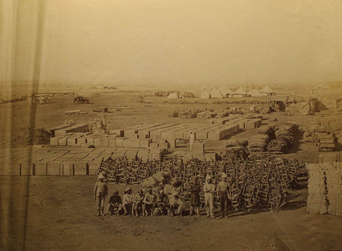 photo of huge numbers of crates and folding chairs in a military camp.