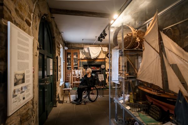 photo of a woman in a wheelchair looking at displays of fishing equipment