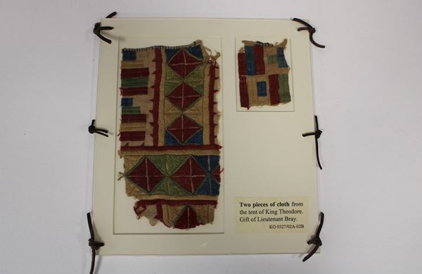 two scraps of cloth completely covered in colourful geometric patterns of rich embroidery.