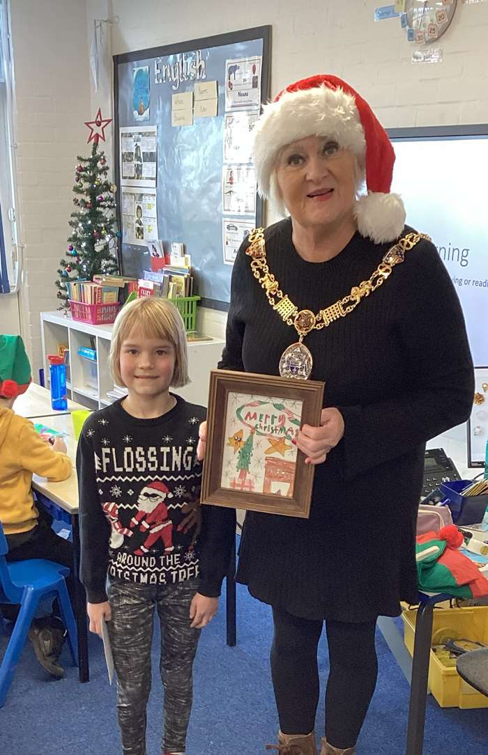 Seven-year-old Clara is congratulated by the Mayor of Lancaster on winning her Christmas card competition