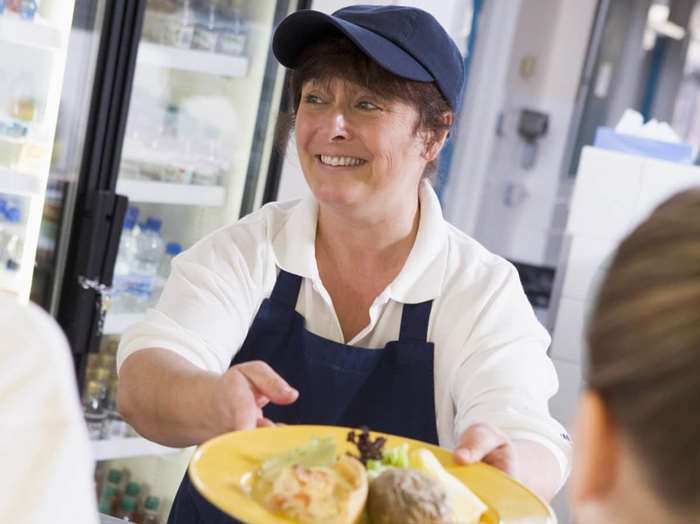 Woman serving food at a cafe counter
